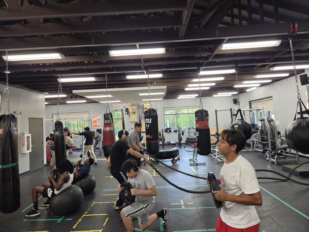 A group training on heavy bags and free weights during circuit training